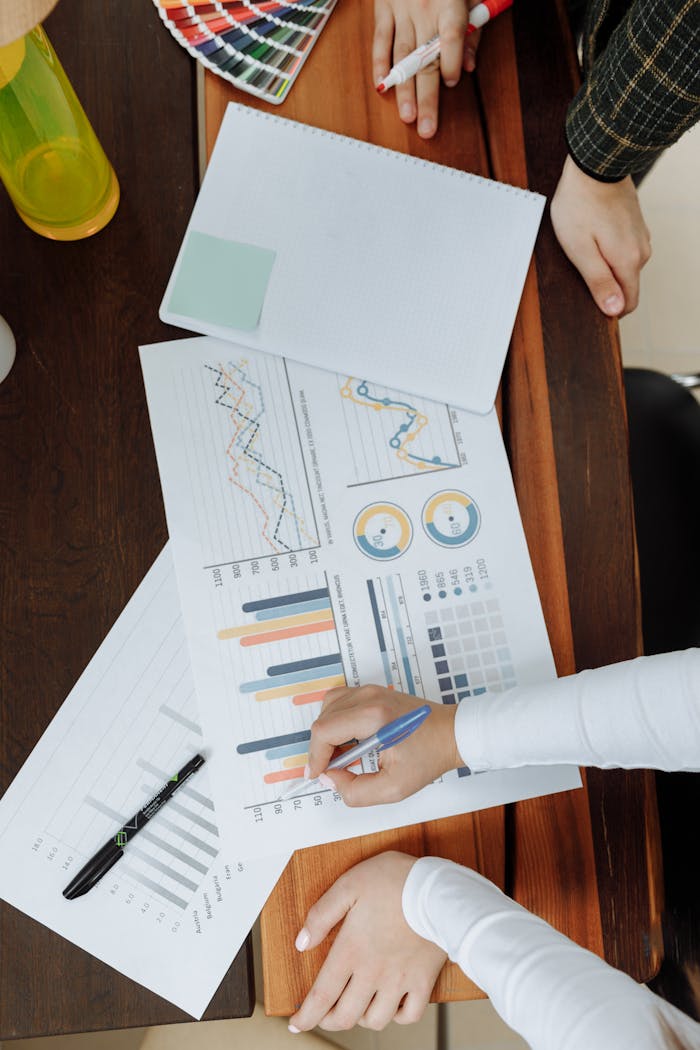 SERVICIOS Top view of business team analyzing charts and data on paper for strategic planning.